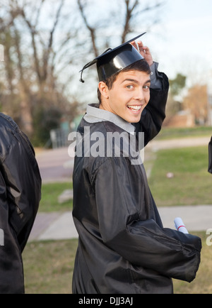 Studente in abito di graduazione Certificato di contenimento del Campus Foto Stock