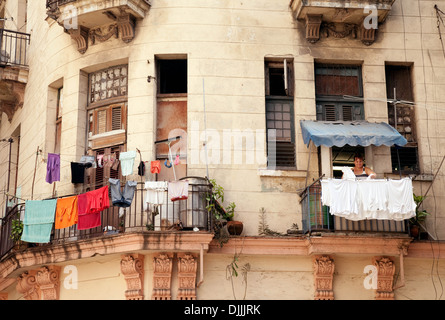 Una donna appendere fuori il suo lavaggio su uno stendibiancheria sul suo balcone, Brasil St, Havana cuba Foto Stock