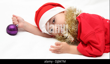 Bambino in santa claus hat giace sul letto Foto Stock