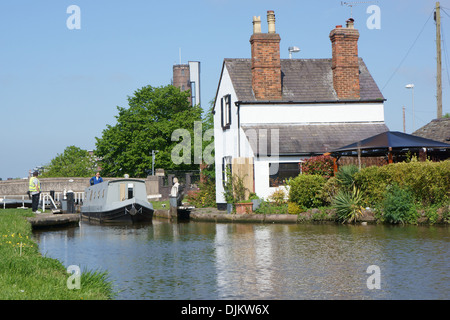 Un narrowboat arriva attraverso una serratura porta sul canale di Chester nel Cheshire, Inghilterra. Foto Stock