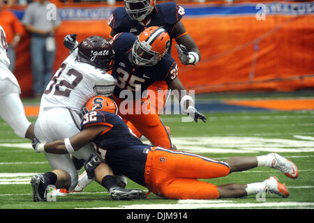 Sett. 25, 2010 - Syracuse, New York, Stati Uniti d'America - Siracusa Orange linebacker Doug Hogue (32) e Siracusa sicurezza arancione Michael Holmes (35) rendono il primo trimestre affrontare su Colgate Raiders running back Nate Eachus (32) Dopo Eachus ha superato la linea di scrimmage. Siracusa sconfitto Colgate 42-7 in due il primo incontro dal 1987 al Carrier Dome in Syracuse, New Foto Stock