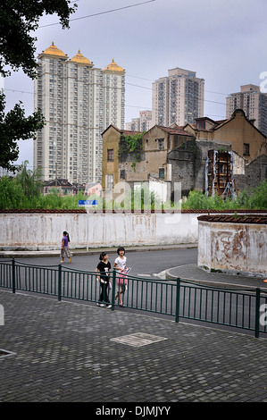 Due ragazze in una strada di Shanghai old town (Nanshi distretto), edifici moderni in background - Cina Foto Stock