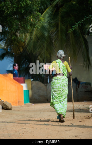 Anziani donna indiana con un bastone a piedi in un territorio rurale villaggio indiano. Andhra Pradesh, India Foto Stock
