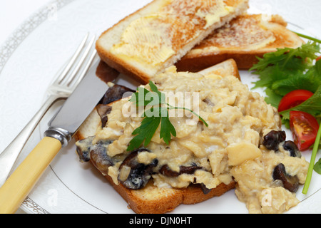 Una colazione o un pranzo leggero a base di uova strapazzate su toast fatto con funghi fritti e scalogno,