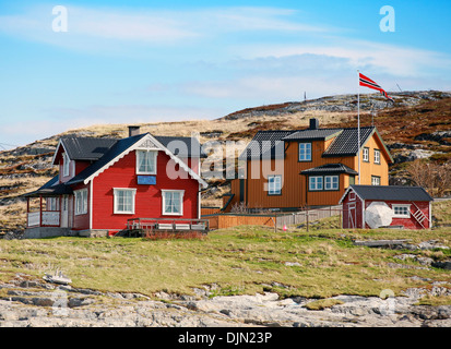 Villaggio norvegese con coloratissime case di legno sulla rocciosa costa del mare Foto Stock