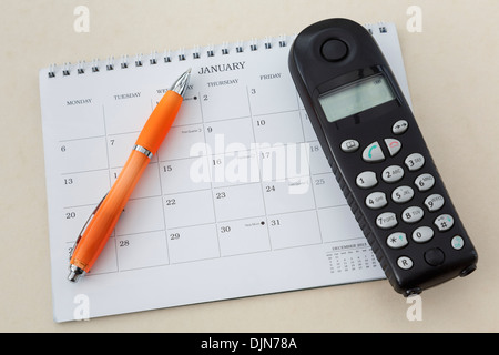 Telefono cordless con una penna e un calendario vuoto sulla pagina per il mese di gennaio 2014 Foto Stock