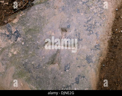 Incisi a croce di malta su una strada piana segni di pietra di inizio del percorso di St Issui è bene su una collina al di sopra del Nant Mair stream. Foto Stock