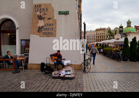 Suonatore ambulante di strada suonando la chitarra in Rynek Glowny la piazza principale del mercato, Città Vecchia, Cracovia in Polonia Foto Stock