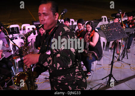 Pasay City a Manila, Filippine. Il 29 novembre 2013. Un Philippine Airforce officer unisce musicisti volontari nella riproduzione di musica all'interno del Villamor Airbase in Pasay City, a sud di Manila, Filippine il Venerdì, 29 novembre 2013. Credito: George Calvelo/Alamy Live News Foto Stock