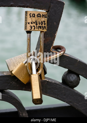 Lucchetti Golden Love Lock fissati su ringhiere metalliche Venezia, Italia Foto Stock