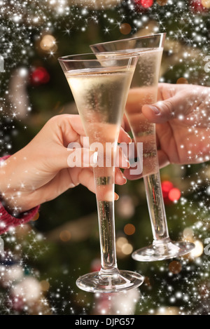 L uomo e la donna la tostatura Champagne nella parte anteriore delle decorazioni, luci e fiocco di neve confine. Foto Stock