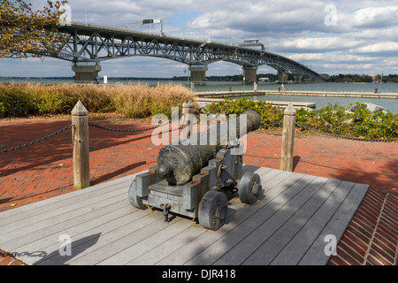 Cannone nel centro storico di Yorktown nel Colonial National Historical Park in Virginia con ponte sul fiume York. Foto Stock