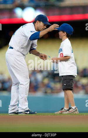 Apr. 29, 2010 - Los Angeles, California, Stati Uniti - 29 Aprile 2010: Los Angeles Dodgers secondo baseman Jamey Carroll (14), la riproduzione di interbase, segni di una sfera per un bambino che partecipano al ''prende il campo con dei Dodgers'' promozione prima del gioco. La Pittsburgh Pirates sconfitto il Los Angeles Dodgers, 2-0, al Dodger Stadium di Los Angeles, California. .Credito: Andrew F Foto Stock