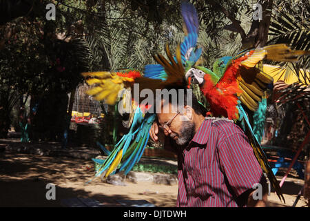 (131130) --Rafah, nov. 30, 2013 (Xinhua) -- un palestinese zookeeper gioca con un 6 mese-vecchio pappagallo a Rafah zoo, nel sud della striscia di Gaza città di Rafah su nov. 30, 2013. Il pappagallo ERA STATA INTRODOTTA DI CONTRABBANDO attraverso il tunnel di Rafah sotto il confine tra Egitto meridionale e la striscia di Gaza città di Rafah, prima le gallerie sono state distrutte dalle autorità egiziane. (Xinhua/Khaled Omar) Foto Stock