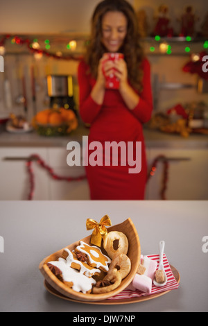 Primo piano sul Natale snack sulla tavola e giovane casalinga in background Foto Stock