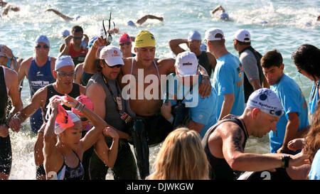 Oct 09, 2010 - Kailua-Kona, Hawaii, Stati Uniti - Un concorrente disabili emerge dalla dura 2.4 miglio nuotare lasciando l'acqua con una assistenza per la transizione verso la fase di biciclette durante il 2010 Ford Ironman a partire dal campionato del mondo Kailua-Kona. (Credito Immagine: © L.E. Baskow/ZUMApress.com) Foto Stock