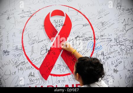 Jakarta, Indonesia. 1 dicembre, 2013. Una donna indonesiana segni su una scheda durante una HIV/AIDS campagna di sensibilizzazione sulla Giornata mondiale contro l AIDS a Jakarta. Credito: Zulkarnain/Xinhua/Alamy Live News Foto Stock