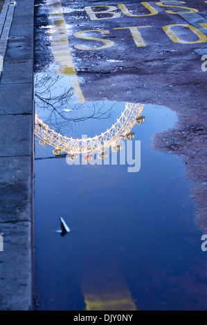 London Eye riflesso in una pozza Foto Stock