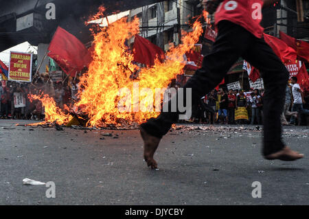 Manila, Filippine. 30 Novembre, 2013. Alcuni manifestanti corrono intorno al bruciato effige gridando le loro proteste presso la storica Mendiola Bridge di San Miguel, Manila il Sabato, 30 novembre 2013. I gruppi militanti mark patriota filippino, Andres Bonifacio il 150° compleanno, tenendo le proteste e le varie attività di Manila. Citando che il presidente avrebbe guadagnato Bonifacio ire, la protesta è guidata dal diritto del lavoro nazionale centro Kilusang Mayo Onu (KMU), coincidente con altri gruppi di lavoro' proteste in tutto il paese.Foto: George Calvelo/NurPhoto Credito: George Calvelo/NurPhoto/ZUMAPRESS.com/Alamy Live News Foto Stock