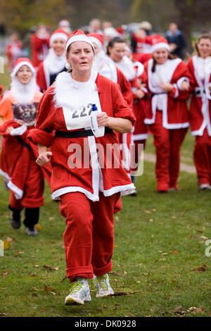 I corridori prendere parte all'annuale Santa 5km Fun Run in Bushy Park, Hampton, TW11 0EQ UK l'evento è quello di raccogliere fondi per la principessa Alice Ospizio. © David Gee. Foto Stock