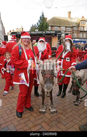 Bromley, Regno Unito. 1 Dic 2013. Santa Dash runner posano con le renne Bromley High Street prima di cambiare le luci di Natale a. Credito: Keith Larby/Alamy Live News Foto Stock