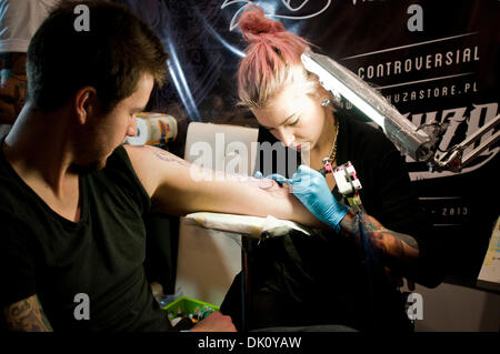 Varsavia, Polonia. Il 1 dicembre 2013. Femmina artisti del tatuaggio fare un nuovo tatuaggio sul suo cliente del braccio durante il secondo giorno del tatuaggio, la verniciatura della scocca e pierceing show - 1a Varsavia Tattoo Convention 2013 in Pepsi Arena a Varsavia in Polonia Credito: kpzfoto/Alamy Live News Foto Stock