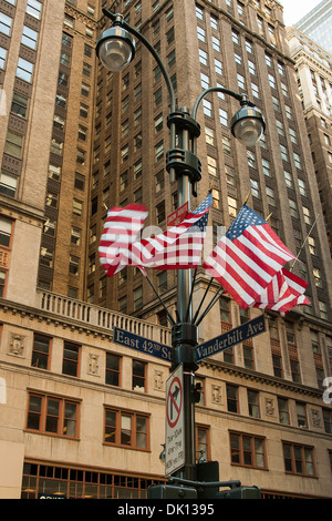 Bandierine americane si muovono nel vento attaccato ad un lampione sull'angolo di East 42th St e Vanderbilt Avenue in New York City Foto Stock