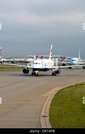 La linea di aeromobili in attesa di decollare da Londra Heathrow su una mattina di occupato Foto Stock
