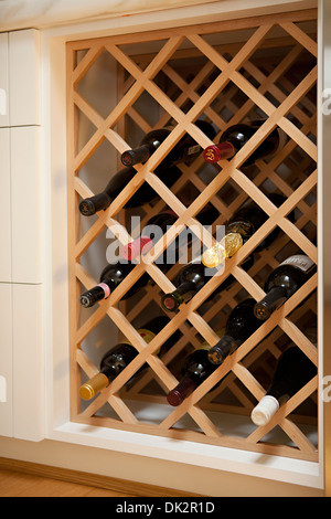 Le bottiglie di vino in built-in legno rack di vino Foto Stock