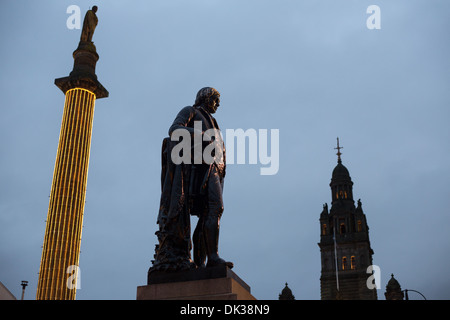 Statua del poeta Scozzese Robert Burns (in primo piano) e scrittore scozzese Sir Walter Scott (in alto a sinistra), in George Square, Glasgow, Scozia. Foto Stock