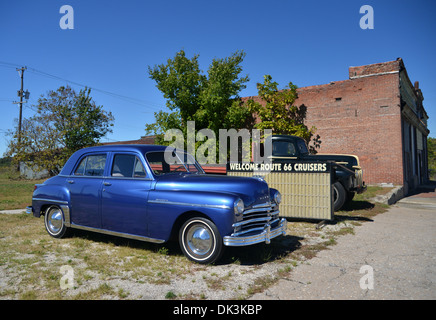 1948 Plymouth Offerte De Luxe parcheggiata da un 'Benvenuti Route 66 incrociatori " segno e un 40s Ford Truck in Galena, Kansas Foto Stock