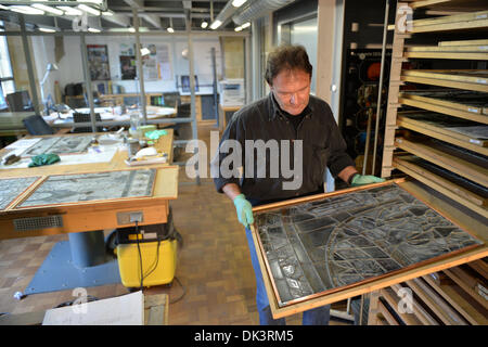 Erfurt, Germania. 27 Nov, 2013. Thomas Vetro, vetraio e restauratore nel laboratorio di vetro della Cattedrale di Erfurt, guarda un costruito fuori della finestra della Cattedrale di Erfurt, Germania, 27 novembre 2013. Il restauro della Cattedrale di una finestra che è costituita da un centinaio di riquadri singolo dura circa due anni. Le finestre sono state realizzate negli anni tra il 1380 e il 1420. Foto: Marc Tirl/ZB/dpa/Alamy Live News Foto Stock