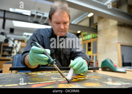 Erfurt, Germania. 27 Nov, 2013. Thomas Vetro, vetraio e restauratore nel laboratorio di vetro della Cattedrale di Erfurt, lavora ad una costruita fuori della finestra della Cattedrale di Erfurt, Germania, 27 novembre 2013. Il restauro della Cattedrale di una finestra che è costituita da un centinaio di riquadri singolo dura circa due anni. Le finestre sono state realizzate negli anni tra il 1380 e il 1420. Foto: Marc Tirl/ZB/dpa/Alamy Live News Foto Stock