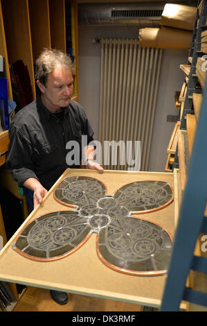 Erfurt, Germania. 27 Nov, 2013. Thomas Vetro, vetraio e restauratore nel laboratorio di vetro della Cattedrale di Erfurt, mette via una parte di una finestra della Cattedrale di Erfurt, Germania, 27 novembre 2013. Il restauro della Cattedrale di una finestra che è costituita da un centinaio di riquadri singolo dura circa due anni. Le finestre sono state realizzate negli anni tra il 1380 e il 1420. Foto: Marc Tirl/ZB/dpa/Alamy Live News Foto Stock