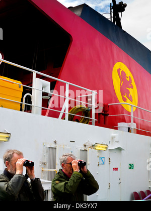 I passeggeri con il binocolo accanto a imbuto di Caledonian MacBrayne traghetto per auto Clansman in rotta verso le Ebridi Interne in Scozia UK Foto Stock