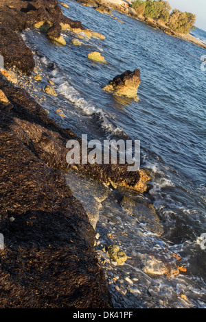 Bold acque - In Grecia, queste forti e acque scure che si schiantano contro la riva, lasciando solo un suggerimento di cielo in alto a destra Foto Stock