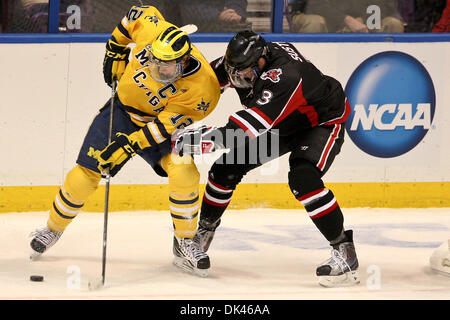 Mar 25, 2011 - Saint Louis, Missouri, Stati Uniti - Michigan avanti Carl Hagelin (12) e ONU defenceman Andrej Sustr (3) battaglia per il puck durante il primo turno della NCAA Division I maschile di hockey su ghiaccio West Regional congelati quattro partita del torneo tra l'Università del Michigan Ghiottoni e l'Università del Nebraska a Omaha non conformisti al Scottrade Center di Saint Louis, Missour Foto Stock