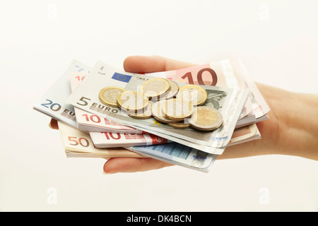 Fan di banconote e monete con la mano Foto Stock