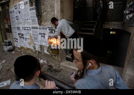 Gerusalemme. 2° dicembre 2013. Un Ebreo Ultra-Orthodox illumina il quinto Hanukkah candela con il suo bambino durante la festa ebraica di Hanukkah a Gerusalemme di Mea Shearim quartiere, il 2 dicembre, 2013. Hanukkah, noto anche come il Festival delle Luci, è una delle più importanti festività ebraiche e celebrato dagli ebrei in tutto il mondo durante otto giorni per commemorare la riconsacrazione del santo tempio di Gerusalemme al tempo della rivolta dei Maccabei del II secolo A.C. (Xinhua/Muammar Awad/Alamy Live News) Foto Stock