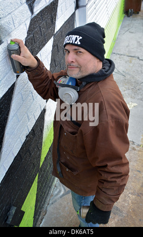 Rinomato artista di graffiti Sexer James Rodriguez la pittura di un murale in Bushwick di Brooklyn, New York Foto Stock