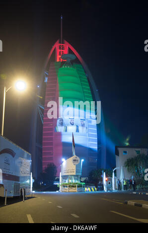 Dubai, EAU. 2° dicembre 2013. Il quarantaduesimo anniversario della fondazione Emirates è stato celebrato in Dubai. Il Burj al Arab facciata è stato coperto con la bandiera nazionale di colore e un omaggio alla scheiks e nella strada di Jumeirah Emirates giovani spruzzata automobili e persone. Credito: jonatha borzicchi editoriale/Alamy Live News Foto Stock