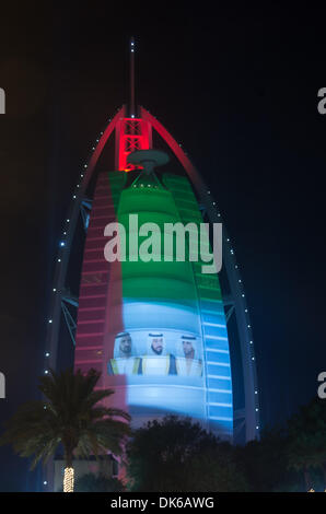 Dubai, EAU. 2° dicembre 2013. Il quarantaduesimo anniversario della fondazione Emirates è stato celebrato in Dubai. Il Burj al Arab facciata è stato coperto con la bandiera nazionale di colore e un omaggio alla scheiks e nella strada di Jumeirah Emirates giovani spruzzata automobili e persone. Credito: jonatha borzicchi editoriale/Alamy Live News Foto Stock