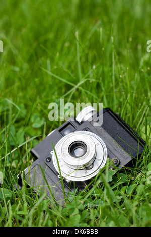 Vecchio classico russo realizzato fotocamera a pellicola noto come Cmena a terra sull'erba verde Foto Stock