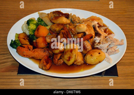 Tradizionale arrosto della domenica pollo a cena con arrosti di ortaggi a radice e il sugo di carne Foto Stock