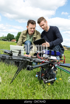 I tecnici a discutere su tavoletta digitale da UAV Foto Stock