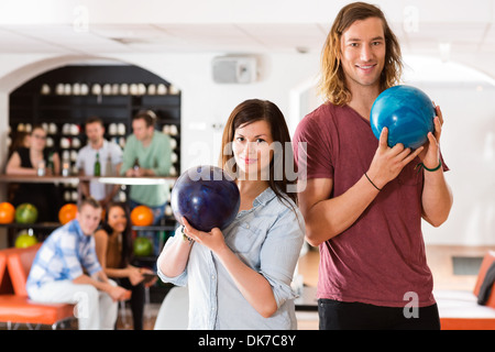 Uomo e Donna che mantiene le palle da bowling nel Club Foto Stock