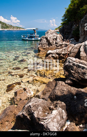 Un pescatore greco lavorando sulla sua barca nella baia del cimitero. Foto Stock