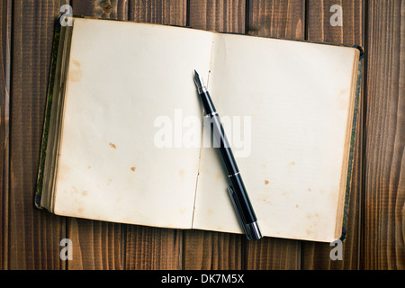 Vista superiore del vecchio libro aperto con penna stilografica sul tavolo di legno Foto Stock