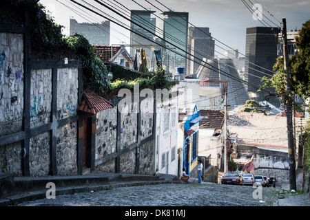 Strade lastricate di Santa Teresa Street con il Rio il distretto commerciale in background. Rio de Janeiro Foto Stock