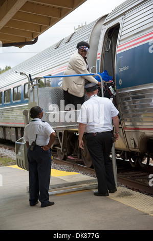 Signora usando un portatile di servoscala a bordo di un treno Amtrak a DeLand Station Florida USA Foto Stock